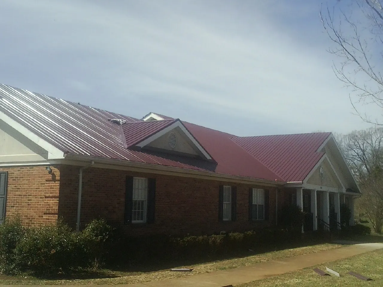 Red metal roof with gabled entries on a long brick building in Dodge City