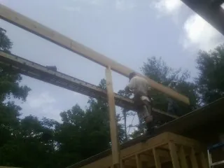 Carpenter setting a ridge beam over a new addition frame — Ice Dam Removal by Roofing Brothers in Dodge City