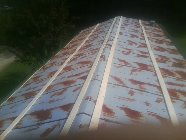 Rusted metal roof panels with new wood purlins before replacement — Storm Damage Roof Repair in Dodge City by Roofing Brothers
