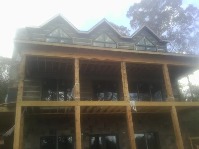 Dormers and porch framing on a large log home under construction — Roof Coating work by our crew in Dodge City