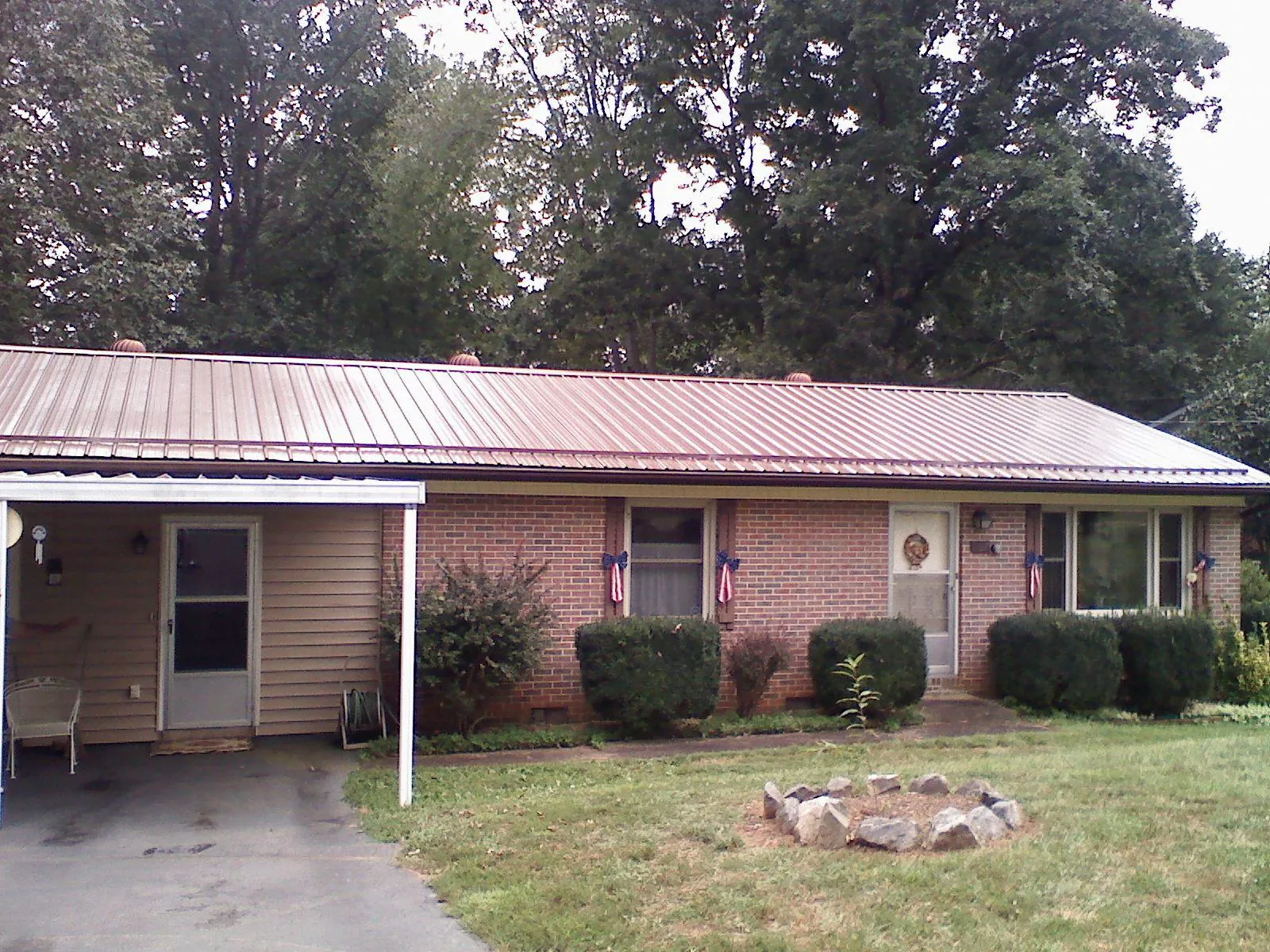 Bronze metal roof and carport on a brick ranch home — Roof Repair work by our crew in Dodge City