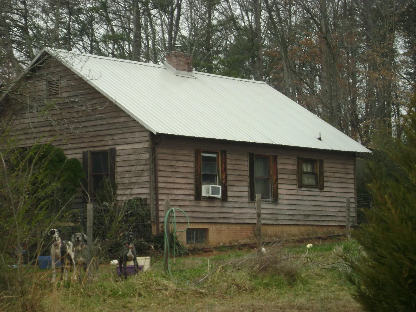 White metal roof on an old wood sided farmhouse, from a Metal Roof Installation job in Dodge City